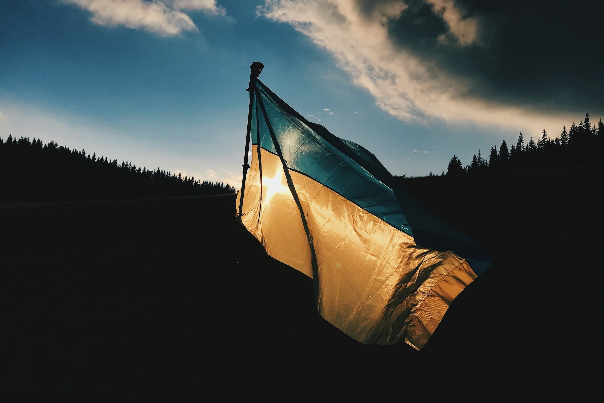 Ukrainian flag backlit by the setting sun
